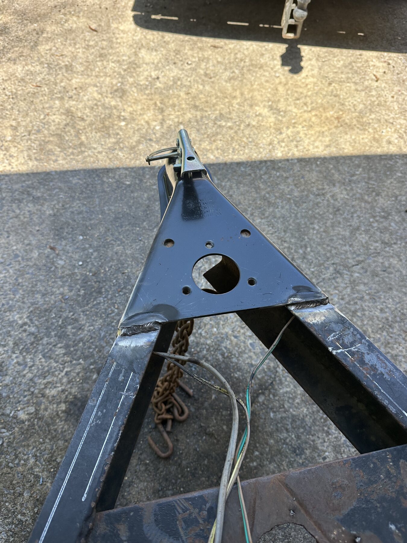 New trailer hitch fitted to the trailer tongue during repair in Anniston